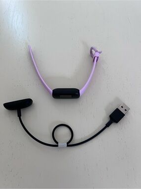 fitbit lavender and black fitness tracker with charger